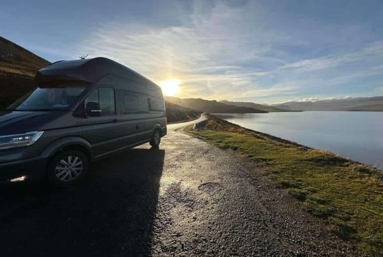 Kamper Volkswagen Grand California na postoju nad fiordem w Norwegii
